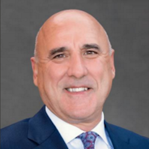 A smiling man in a blue suit jacket
